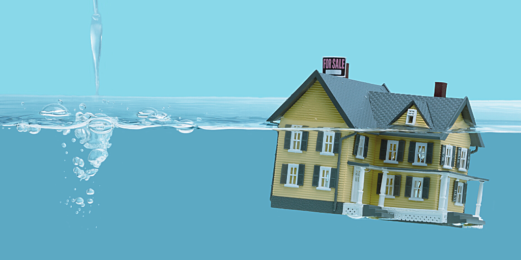 A model house sinking under water.